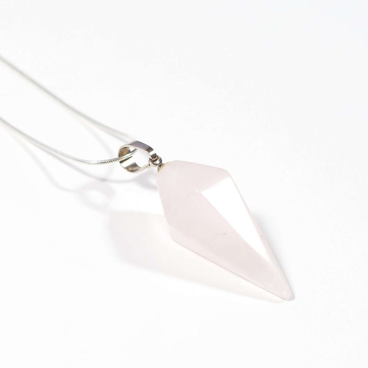 Close up view of rose quartz love crystal pendant with chain.