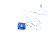 Over head view of  Natural Royal blue lapis lazuli prism crystal pendant with silver tone snake chain.
