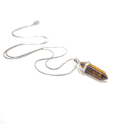 Long range shot of  Tiger's eye natural crystal confidence pendant and chain