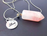 Side view of rose quartz double necklace with sterling silver Love charm and snake chain.