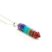 Multi coloured Chakra point pendant - purple blue yellow red orange displayed in necklace.