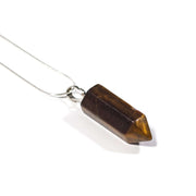Close up of confidence crystal Tiger's Eye bullet pendant with chain.