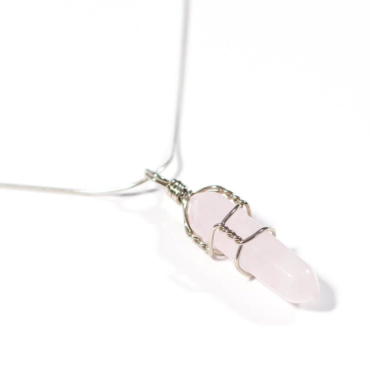 Close up of bullet point wire wrapped rose quartz pendant with snake chain.