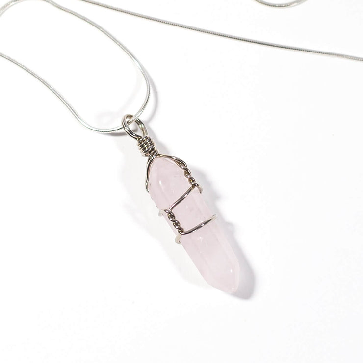 Head on view of Rose Quartz wrapped bullet pendant with silver tone stainless steel chain.